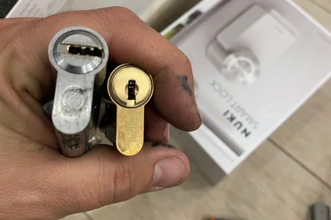 Mano que sostiene un bombín usado junto a uno nuevo de latón
