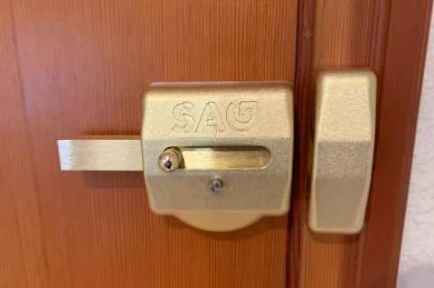 Cerrojo de seguridad de sobreponer instalado en una puerta de madera